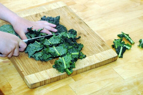 child chopping kale